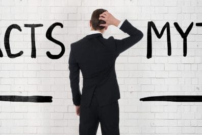 man looking at arrows and writing on wall reading facts and myths